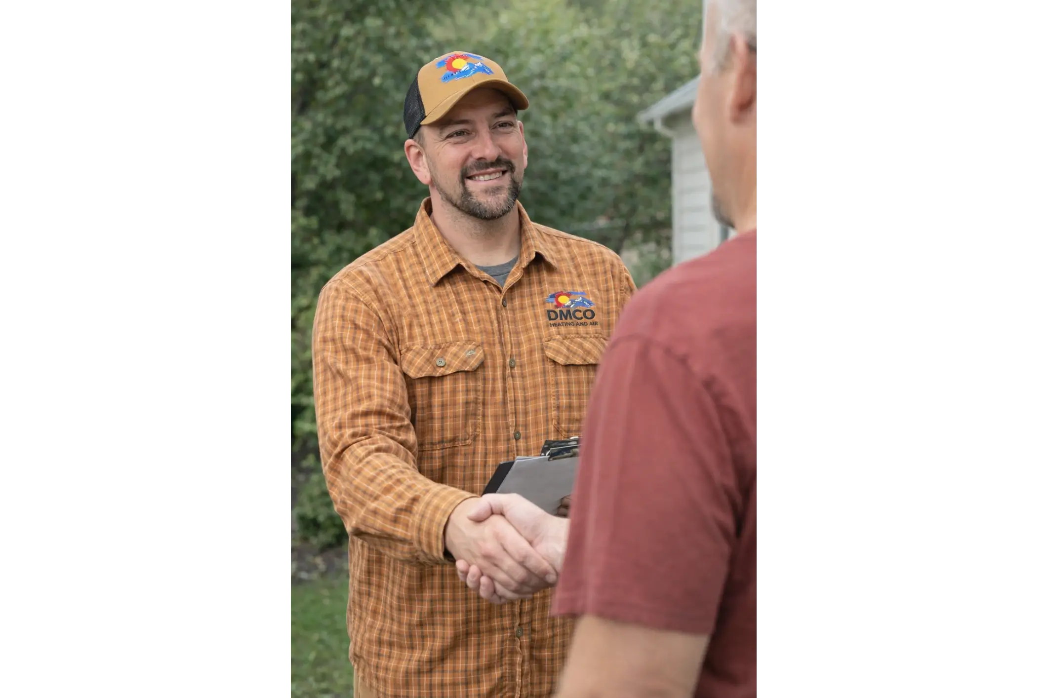 Smiling repair technician shaking hands with homeowner