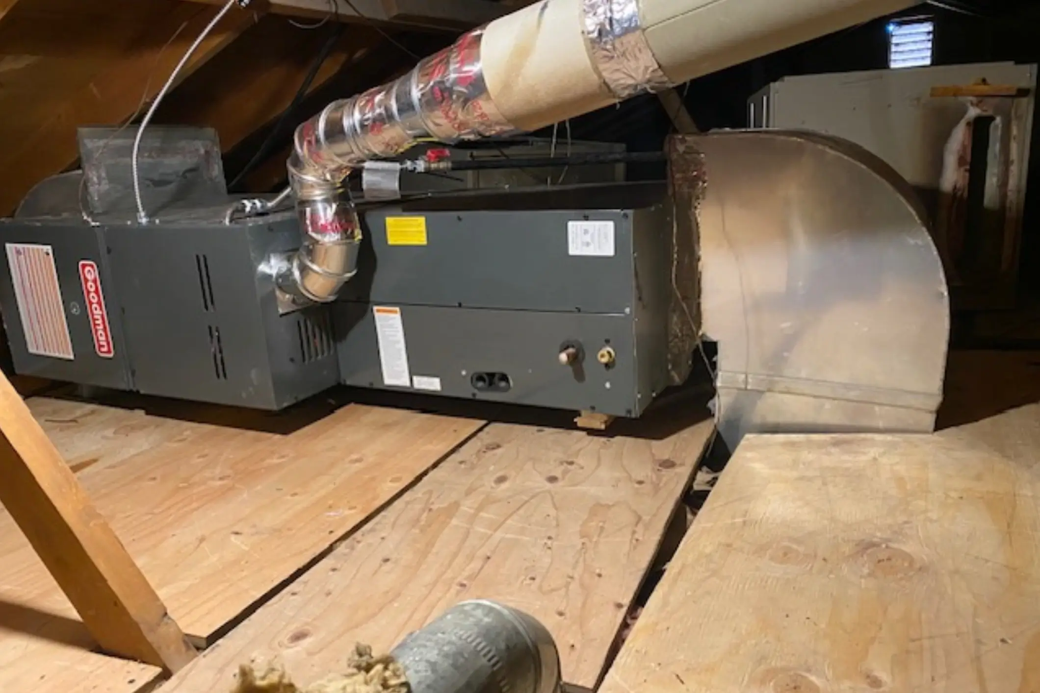 A furnace or HVAC unit installed in a basement with ductwork.