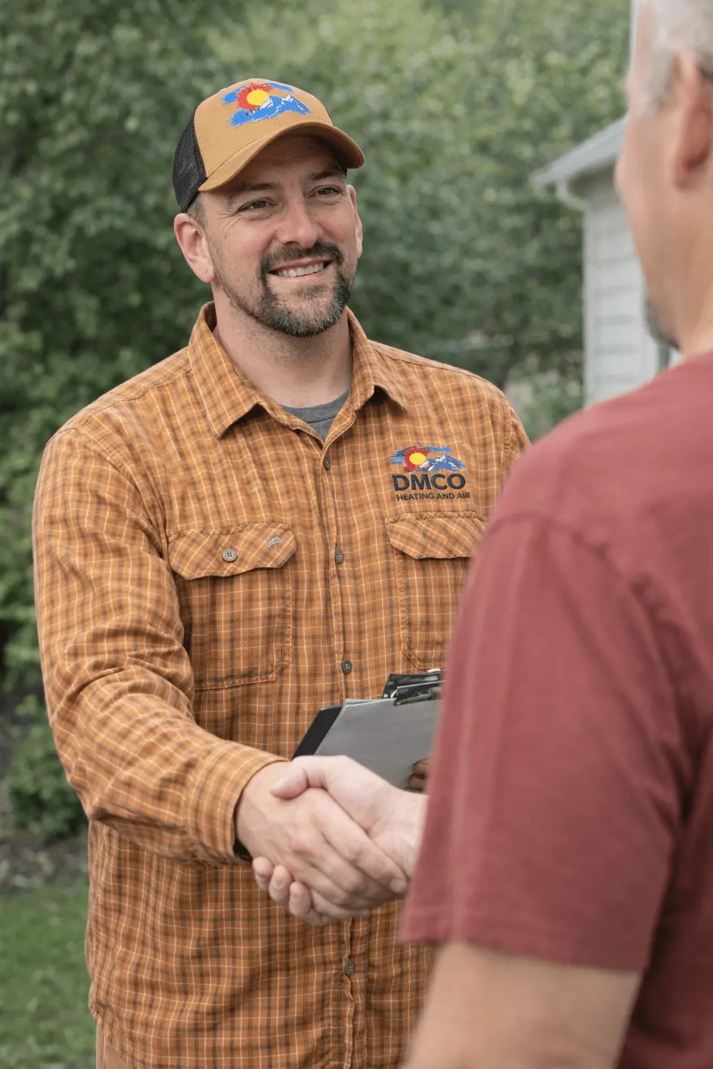Smiling contractor shaking client's hand outdoors
